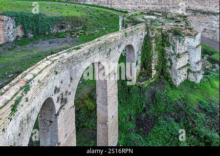 An arched structure with an ancient conduit descending from the Alhambra. Stock Photo