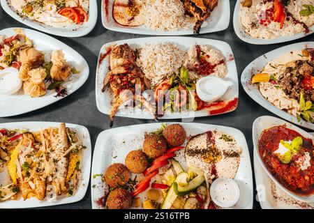 Assorted Mediterranean Dishes with Grilled Meats, Rice, and Dips Top View Stock Photo