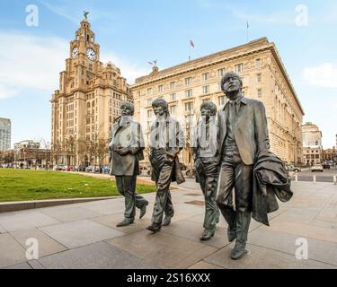 Bronze statues of the four Beatles created by sculptor Andy Edwards in front of the Liver buildings on the Liverpool pier head waterfront Stock Photo