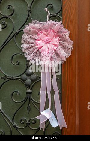Pink decorative bow hanging outside on an entrance door Stock Photo