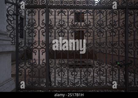 Yard on a side entrance of a palace seen behind an iron fence Stock Photo