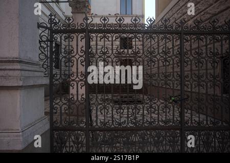 Yard on a side entrance of a palace seen behind an iron fence Stock Photo