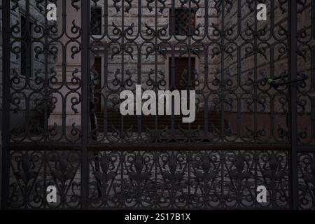 Yard on a side entrance of a palace seen behind an iron fence Stock Photo