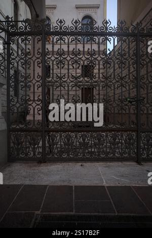 Yard on a side entrance of a palace seen behind an iron fence Stock Photo
