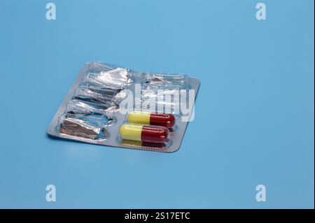 The rest of the antibiotic capsules in a blister pack on a blue background Stock Photo