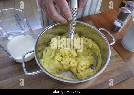 German cuisine, preparation of mashed potatoes for sauerbraten with mashed potatoes, grating nutmeg, grater, seasoning, pot, grandmother's kitchen, re Stock Photo