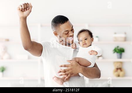 Hapiness Of Fatherhood. Joyful Black Dad Enjoying Spending Time With Infant Child Stock Photo