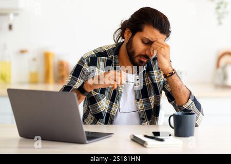 Tired middle-eastern man freelancer having difficulties at job Stock Photo
