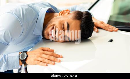 Happy young arab man hugging car of his dream Stock Photo