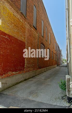 Alley way between brick walls with painted over ghost signs Stock Photo