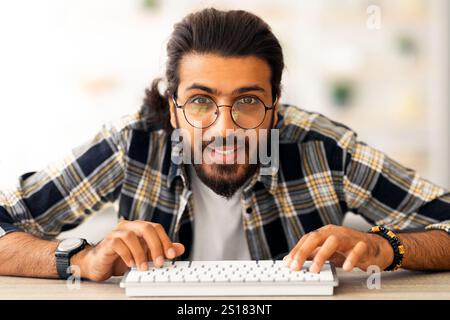 Young middle-eastern man programmer sitting at worktable Stock Photo