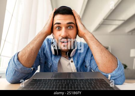 Surprised man having video call using laptop Stock Photo