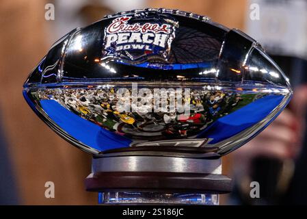 Atlanta, GA, USA. 1st Jan, 2025. Texas crowds around the Peach Bowl trophy after defeating Arizona State in the CFP Quarterfinal at Mercedes-Benz Stadium in Atlanta, GA. (Scott Kinser/CSM). Credit: csm/Alamy Live News Stock Photo