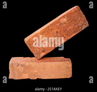 Side view of two old red or orange bricks is isolated on black background with clipping path. Stock Photo