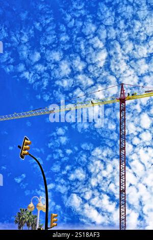 Traffic lights and large industrial building crane against blue sky  and mackerel cloud in Benalmadena Malaga Spain Stock Photo