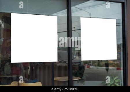 Mockup white poster with black frame stand in front of blur restaurant cafe background for show or present promotion product concept. Clipping path. Stock Photo