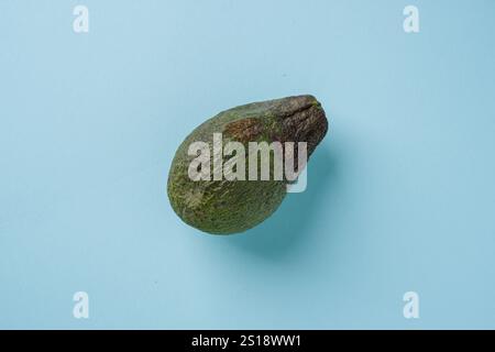 Top view of ripe avocado on blue background Stock Photo