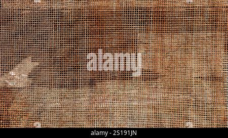 grid rusty structure with small cells in sunlight, industrial abstract background of metal grate, lattice with rust coating full frame Stock Photo