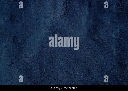 Dark, textured surface featuring a rich navy blue color with subtle abstract details, ideal for use as a background for designs, advertisements, or pr Stock Photo