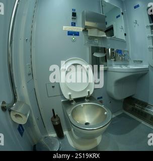Toilet in Railways First Class sleeping carriage of the passenger train: toilet-bowl, washbasin, mirrors and toilet paper box. Stock Photo