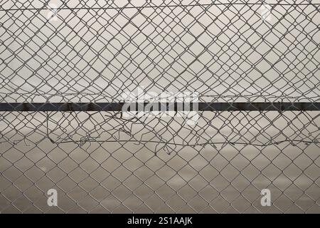 Metal link fence with wire Stock Photo