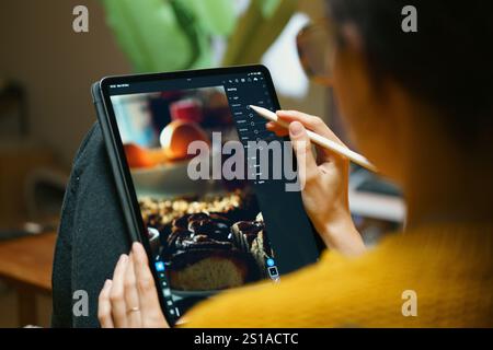 woman photo editing on digital graphic tablet lightroom software relax home living room interior freelance creative work Stock Photo