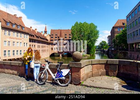 Germany, Bavaria, Franconia, Nuremberg, Old town, along Pegnitz River, Museum bridge (Museumsbrücke) and Holy Spirit Hospital in the background Stock Photo