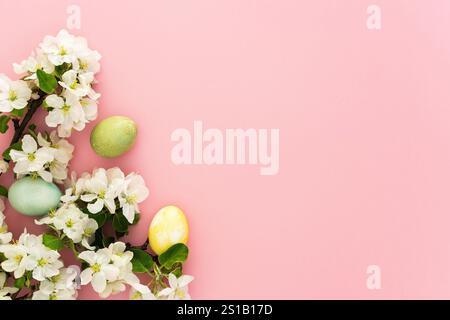 Spring Easter background, multi-colored Easter eggs and blooming apple tree branches on a pink background Stock Photo