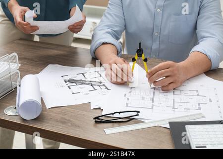 Architects working with project, closeup. Different technical drawings on wooden table Stock Photo