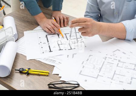 Architects working with project, closeup. Different technical drawings on wooden table Stock Photo
