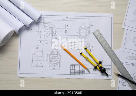 Different engineering drawings, pencils, ruler and divider on wooden table, flat lay Stock Photo