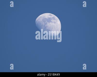 Crescent moon during sunset with blue sky Stock Photo