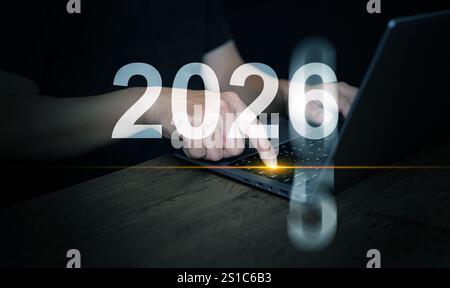 Happy New Year 2026. A man presses enter button on his laptop computer to change the year from 2025 to 2026 to start the new year. Stock Photo