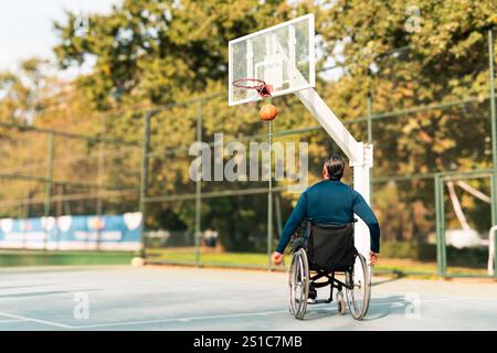 Adult male athlete about 50 years old, practicing basketball in a wheelchair Stock Photo