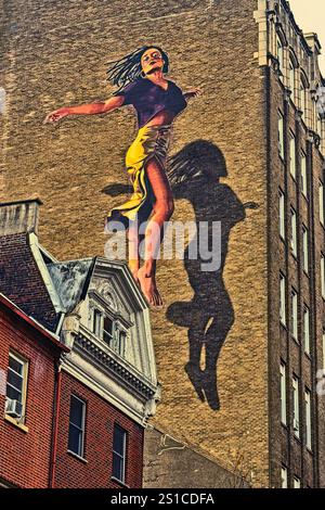 On the building wall: Woman In free flight, Philadelphia, Pennsylvania,  USA Stock Photo