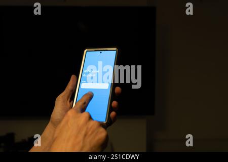 Hands holding smartphone using AI personal assistant app in dark room, innovative technology and communication Stock Photo