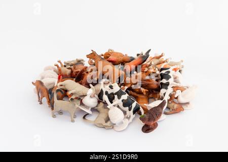 Pile of toy miniature mixed farm animals on white isolated background Stock Photo