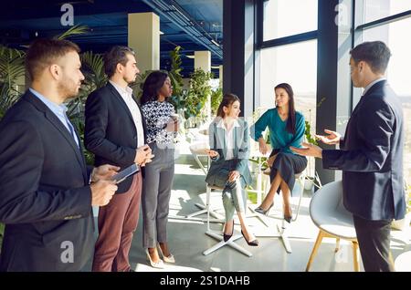 Young business man speaking on a meeting in office during a conference with company employees. Stock Photo