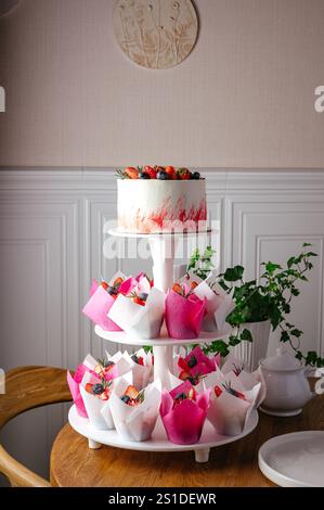 wedding cake on a stand with cupcakes Stock Photo