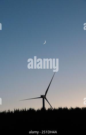 Wind turbine and new moon, in a clear evening sky (UK) Stock Photo