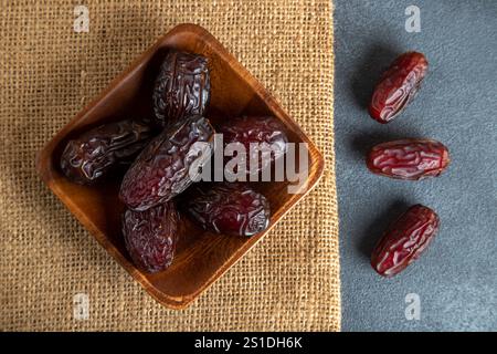 Large dates fruit in a wooden bowl, top view Stock Photo