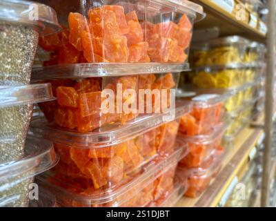 Closeup of stacked plastic containers filled with dried papaya chunks Stock Photo