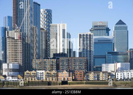 Canary Wharf skyscraper district with residential buildings surrounded by high rise offices and apartments on a sunny day. London - 3rd January 2025 Stock Photo