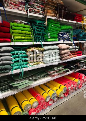 Kyiv, Ukraine - January 03, 2025: Rows of neatly arranged colorful outdoor cushions and mats on store shelves, showcasing various designs and material Stock Photo