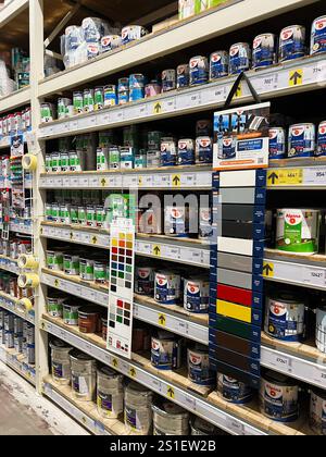 Kyiv, Ukraine - January 03, 2025: An organized selection of paint cans, color swatches, and tape displayed on store shelves. Stock Photo