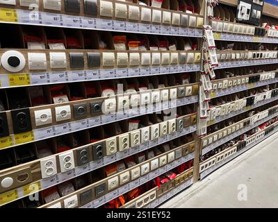 Kyiv, Ukraine - January 03, 2025: A wide variety of electrical outlets and switches are neatly displayed on shelves in a hardware store, showcasing nu Stock Photo