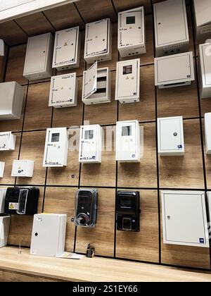 Kyiv, Ukraine - January 03, 2025: An array of electrical meter boxes and equipment panels is displayed on a wooden background, showcasing diverse desi Stock Photo