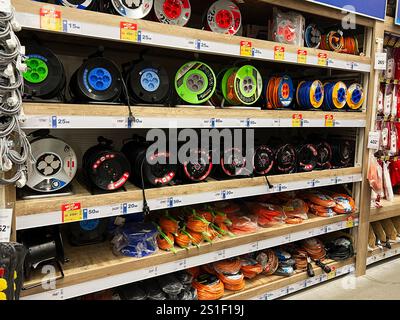 Kyiv, Ukraine - January 03, 2025: Organized shelves displaying various cable reels and electrical extension cords for home or office use. Stock Photo