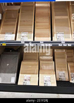 Kyiv, Ukraine - January 03, 2025: Shelves in a hardware store showcasing wooden slatted closet doors of various sizes and styles, neatly arranged and Stock Photo