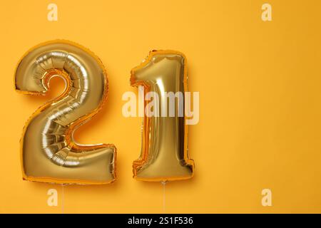 Coming of age party - 21st birthday. Number shaped balloons on orange background, space for text Stock Photo